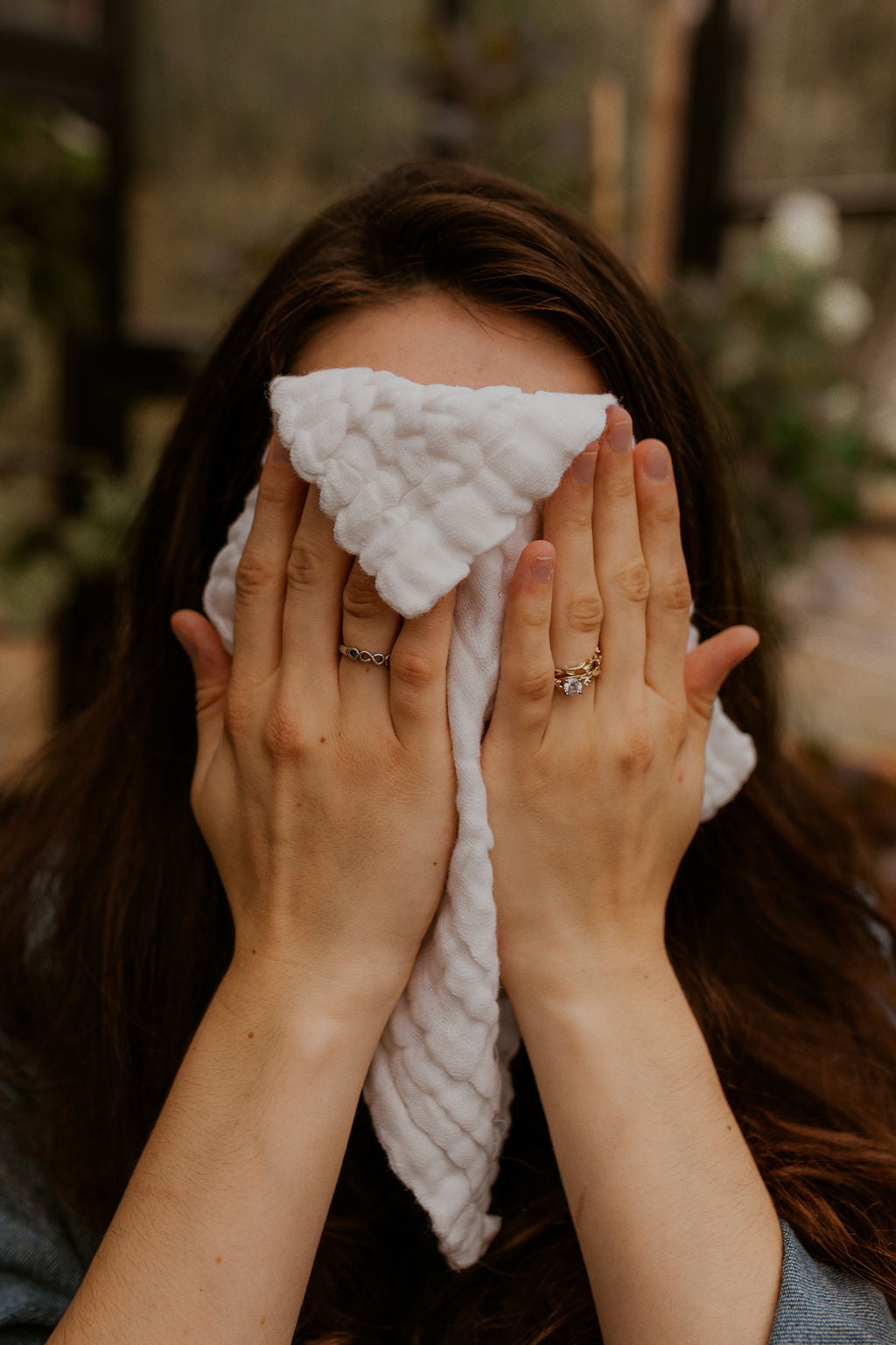 Woman pressing a washcloth to her face to remove oil cleanser